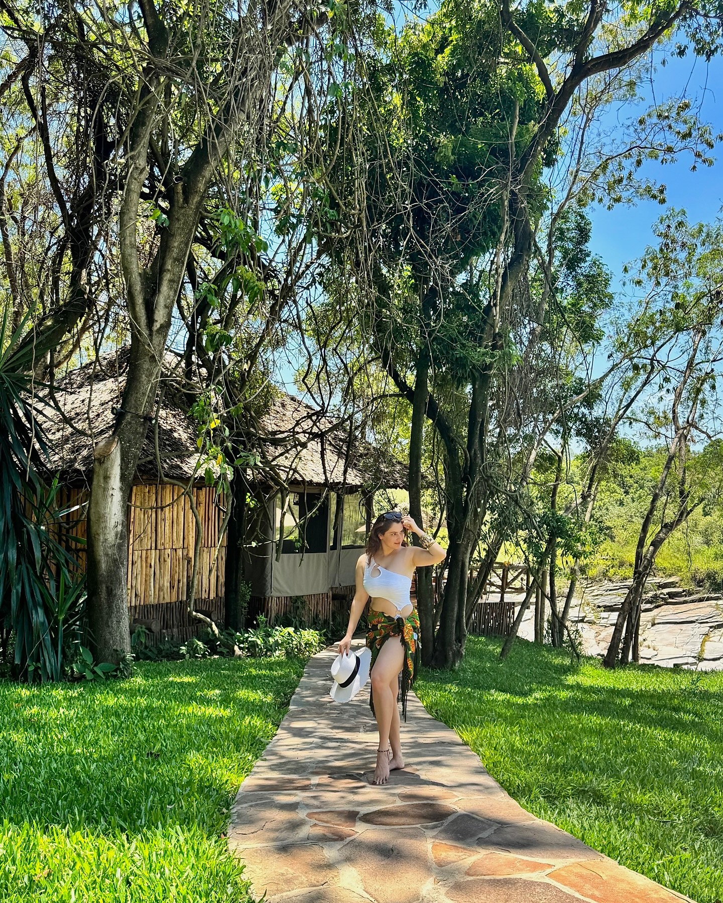 Shivaleeka Oberoi wears a stylish white cut-out bodysuit paired with a vibrant floral sarong, making for a perfect tropical getaway look.