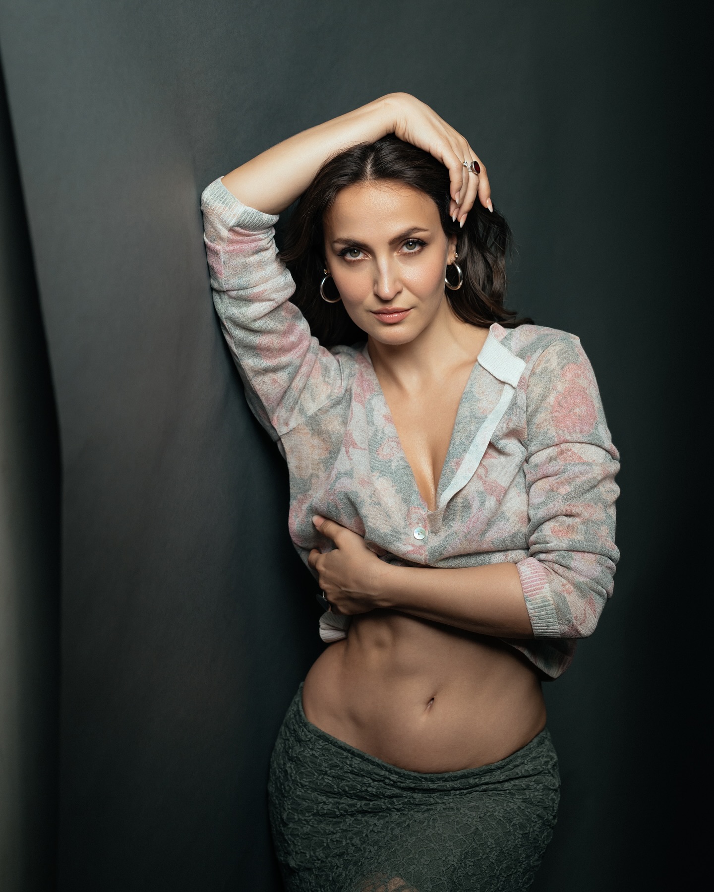 Elli Avram stuns in a floral-patterned cardigan paired with a green skirt.