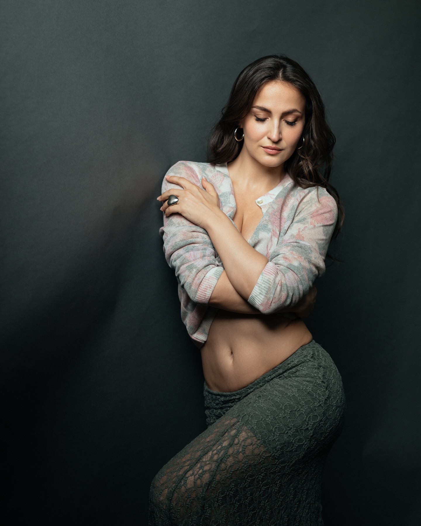 Elli Avram stuns in a floral-patterned cardigan paired with a green skirt.