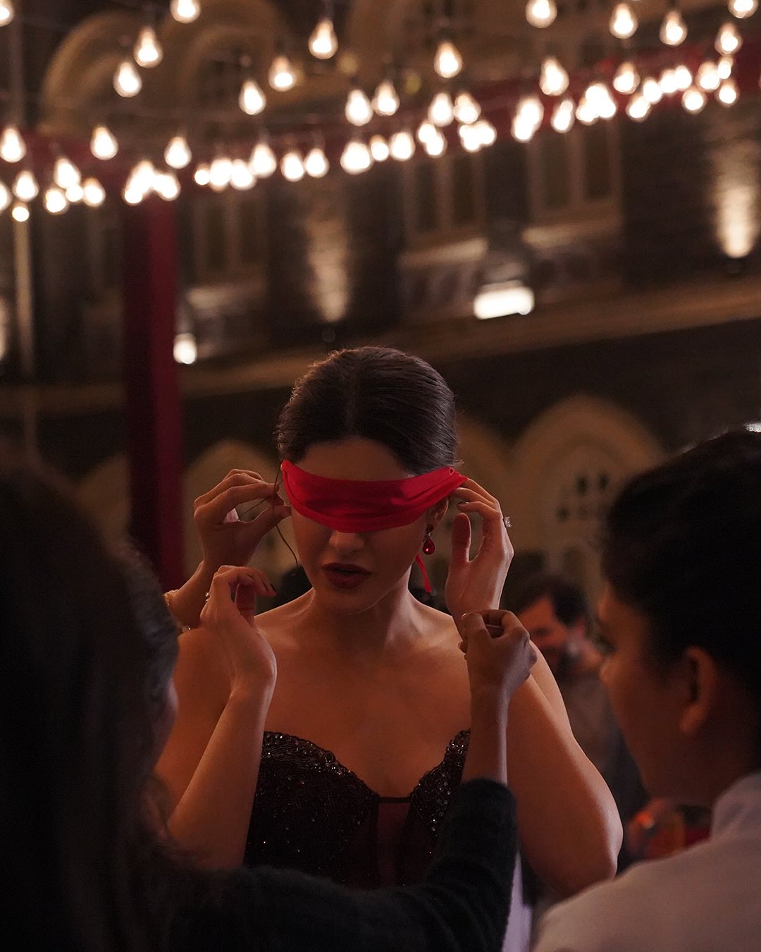 Behind-the-scenes capture: A crew member gently ties a blindfold on Shanaya Kapoor during a pivotal scene