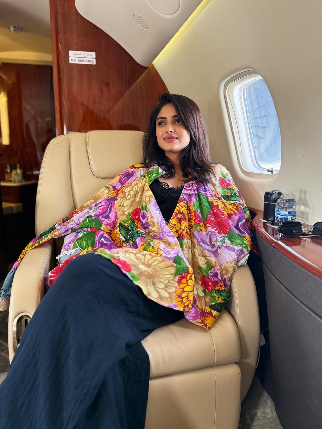 Aysha stuns in a vibrant floral shawl, channeling tropical elegance with effortless flair–turning every airport moment into a style statement
