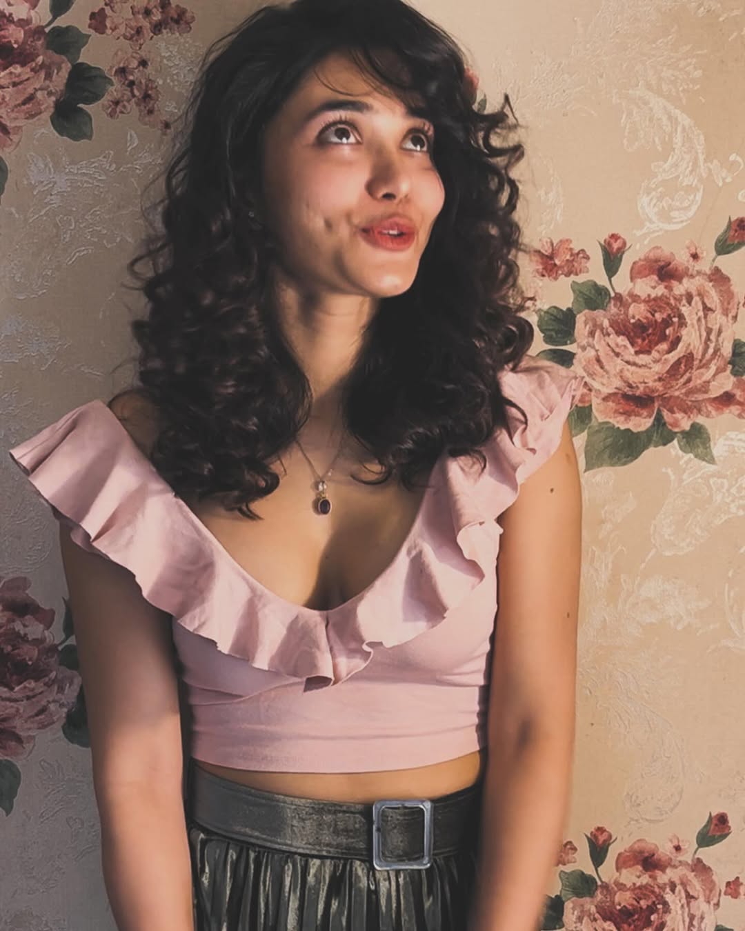 That pink ruffled top? A total bloom moment–Jenifer outshines even the floral wallpaper