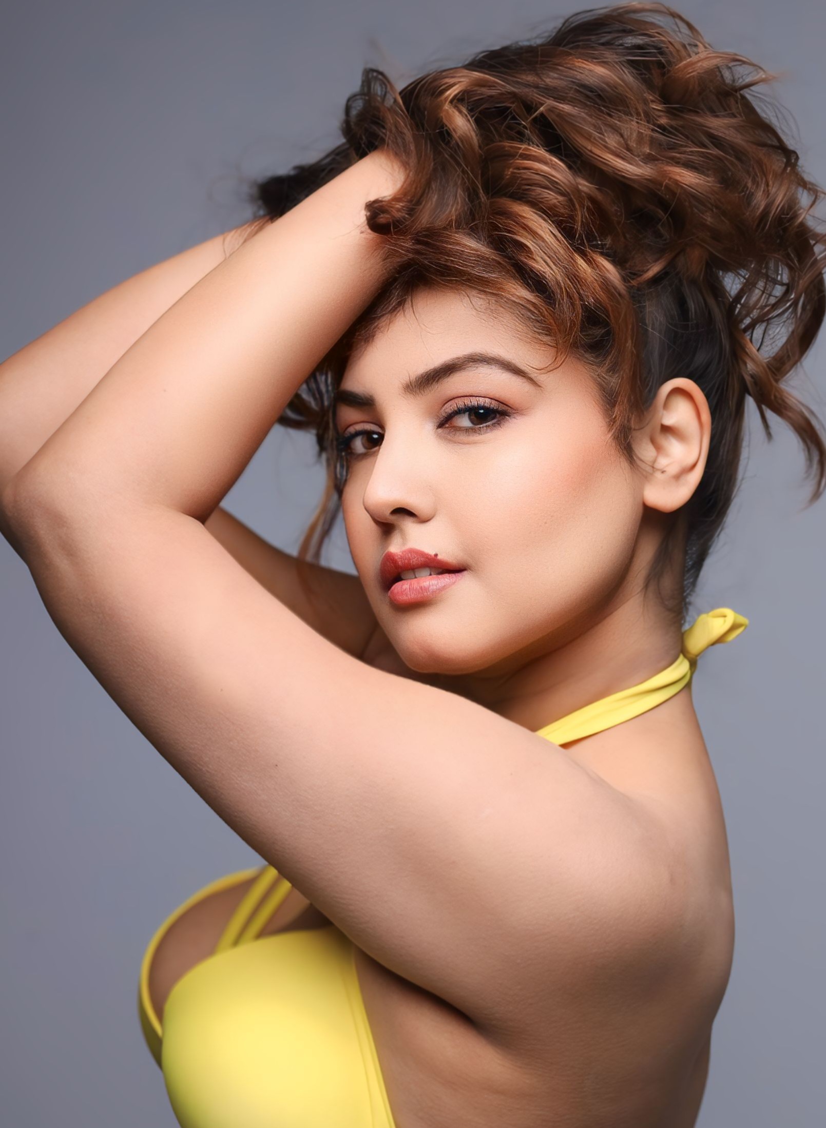 Komal Jha’s confident stance and dazzling smile, paired with her sunny yellow outfit and tousled waves, make it look like she’s not just turning heads–she’s turning up the heat on the thermostat