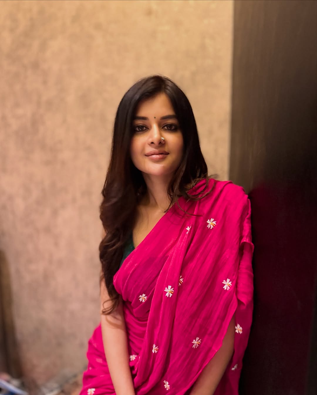 Draped in a vivid pink saree with delicate white floral embroidery, Madhumita Sarcar balances timeless elegance with playful charm