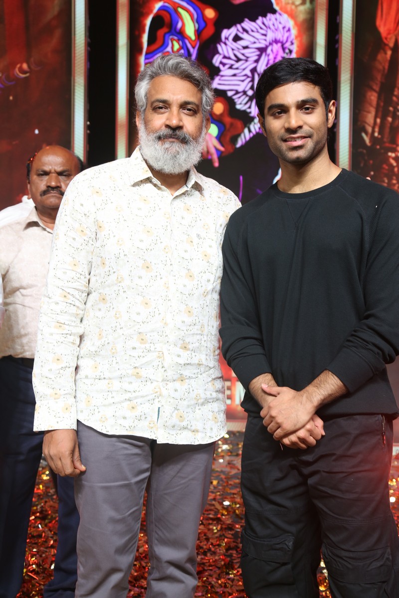 A candid frame of S. S. Rajamouli and lead actor Kireeti Reddy sharing a light moment during the media interaction.