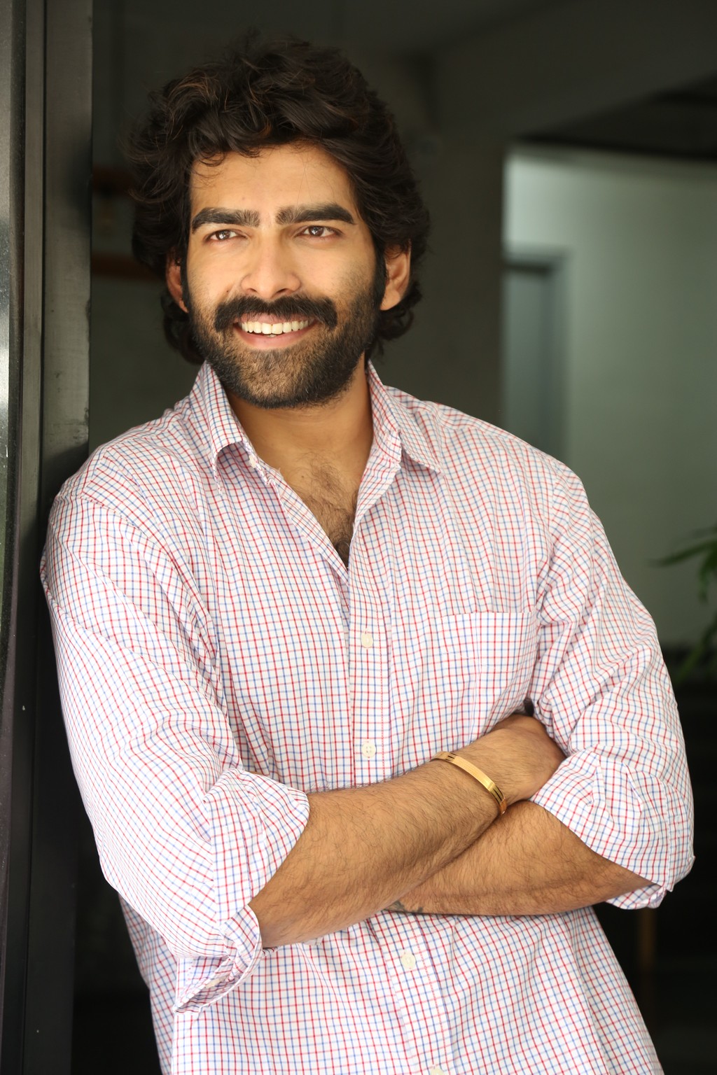 Manoj Chandra embodies casual sophistication, showing how a relaxed smile and a checkered shirt are the secret ingredients to effortless office allure (with just a hint of fun).