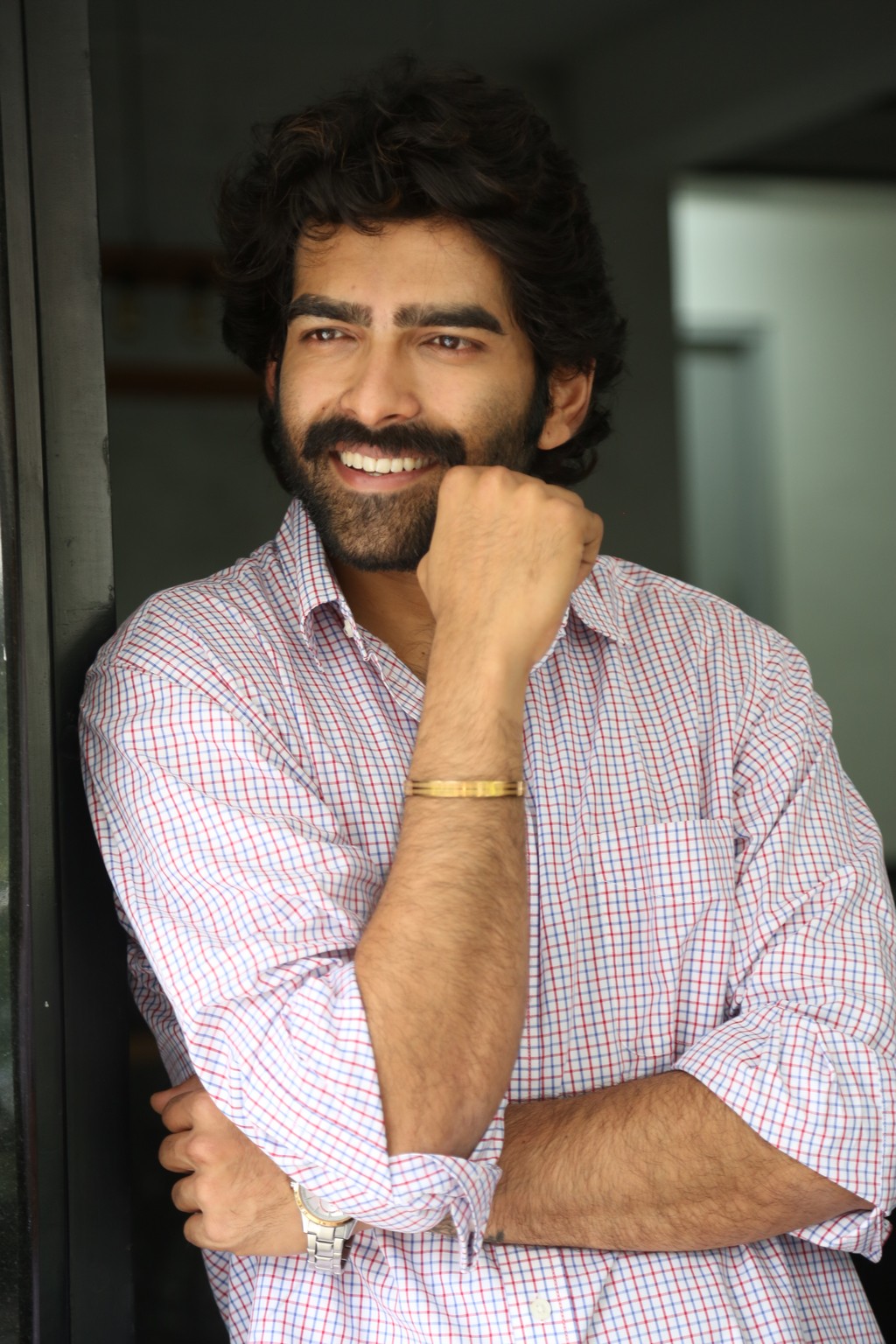 Manoj Chandra blends easy wit with style finesse in his checkered ensemble–because a confident smile and a touch of charm guarantee it’s always a good hair day.