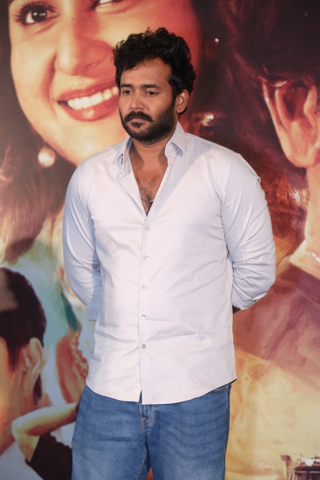 Actor Naresh Agastya seen on stage, engaged and listening during the official proceedings.