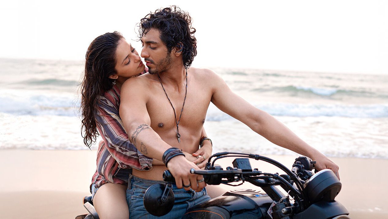 A scenic shot of Ahaan Panday and Aneet Padda riding a motorcycle along the beach.