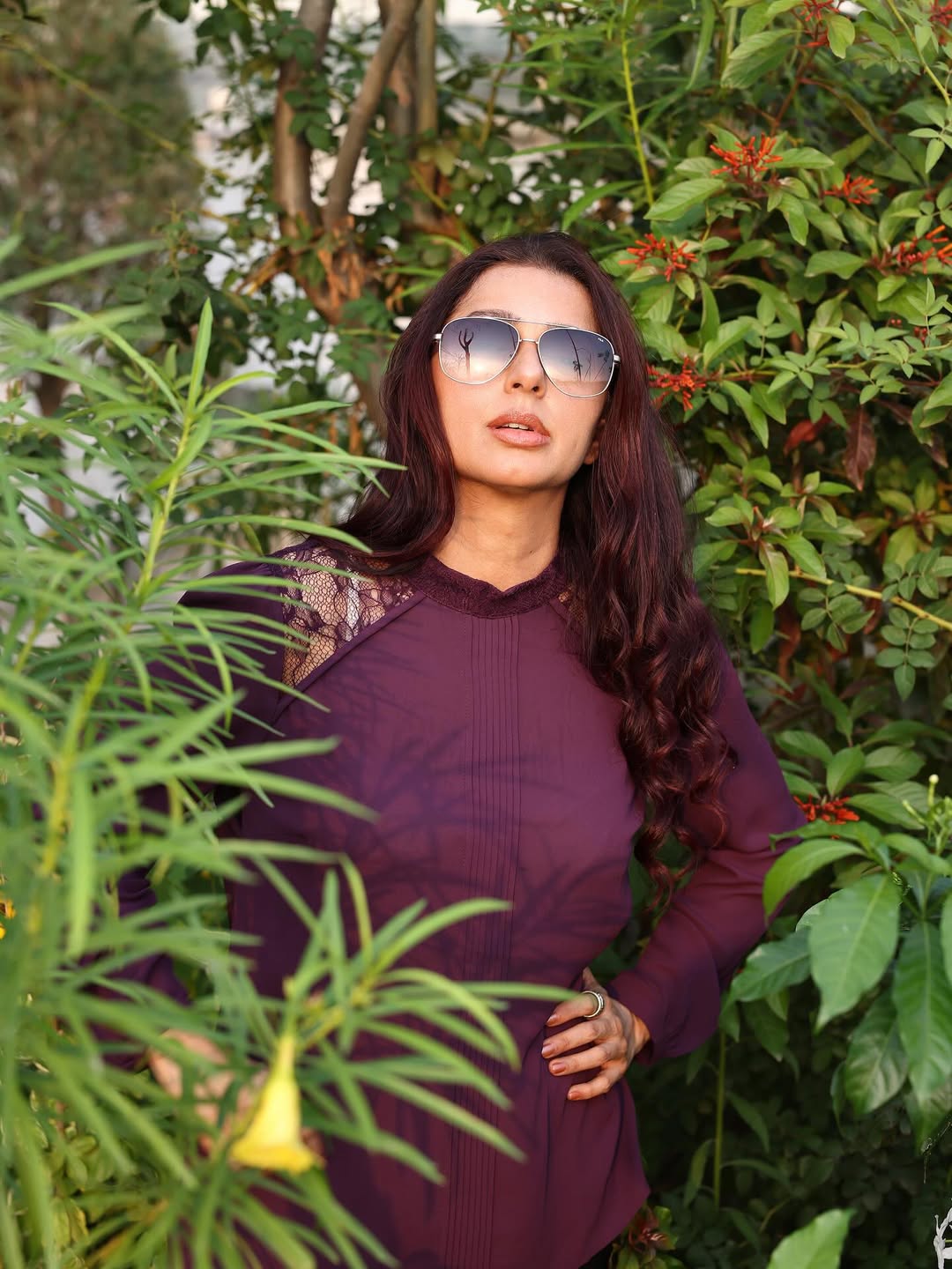Radiating elegance in a deep plum ensemble, she effortlessly blends style and humor–proof that even in a jungle of leaves, her fashion game is in full bloom!