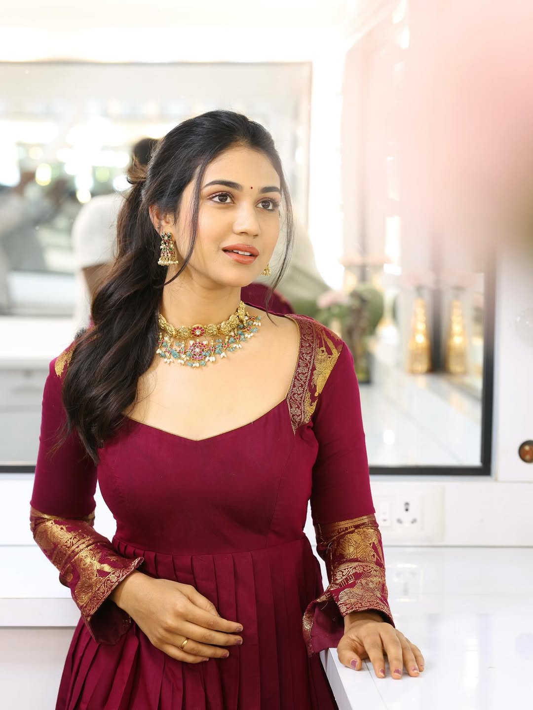 Priyanka Achar exudes timeless elegance in a rich maroon ensemble adorned with gold accents–proof that style and sophistication are always in fashion, with a touch of jewelry that could outshine the jewelry store!