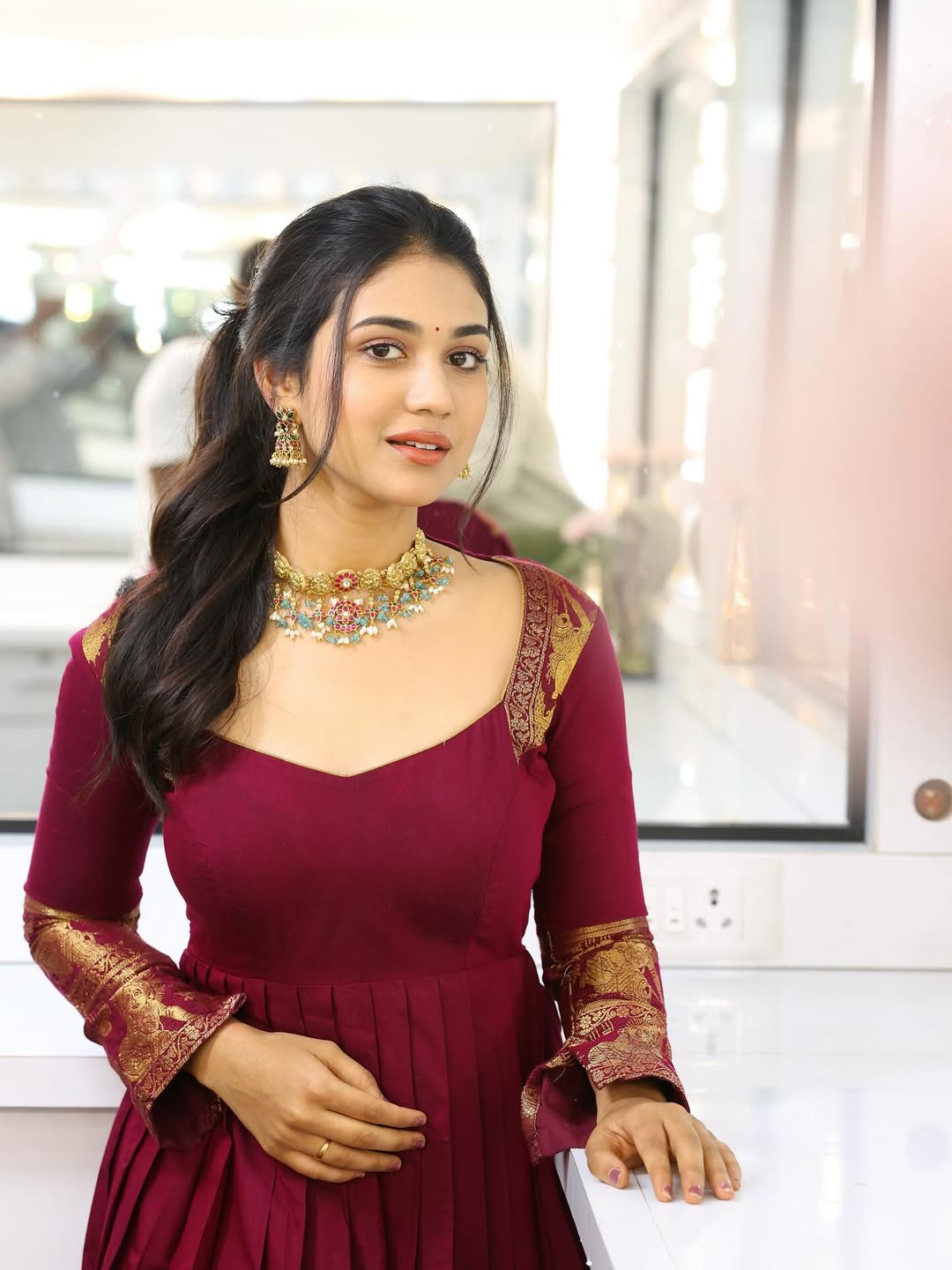 Priyanka Achar radiates timeless elegance in a rich maroon ensemble, perfectly accessorized with dazzling jewelry–proof that style and grace never go out of fashion, even when the face is a mystery!