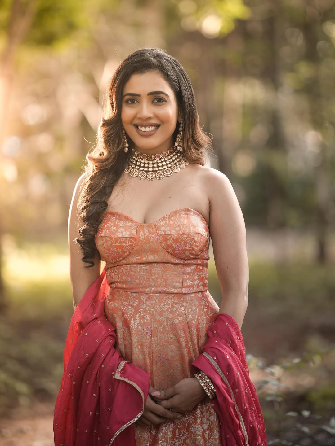 Sara Annaiah exudes timeless elegance in a beautifully embroidered peach saree paired with a stunning pearl necklace, proving that style and grace are always in vogue–even in the great outdoors!