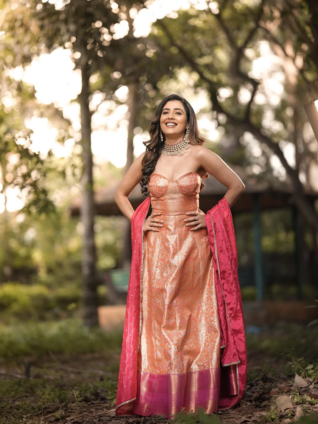 Sara Annaiah showcases stunning traditional elegance in a rich peach saree with intricate gold embroidery, proving that a touch of glamour can make even a forest look fabulous!