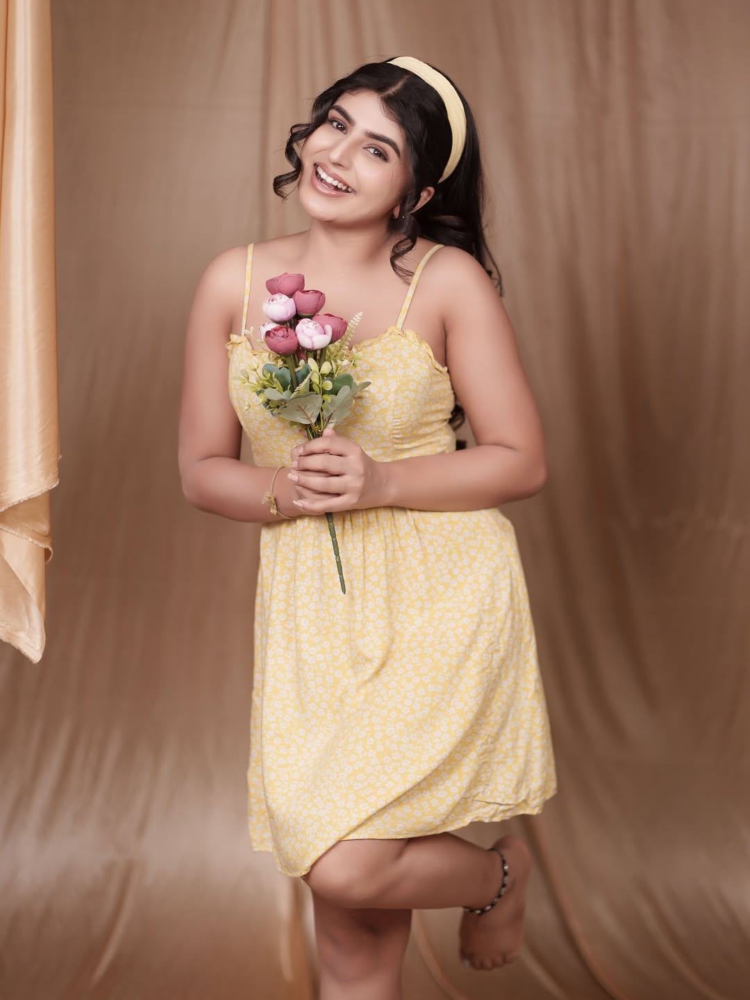 Sharanya Shetty radiates effortless charm in a sunny yellow dress, proving that a floral touch and a bouquet can turn any moment into a stylish bloom of happiness.