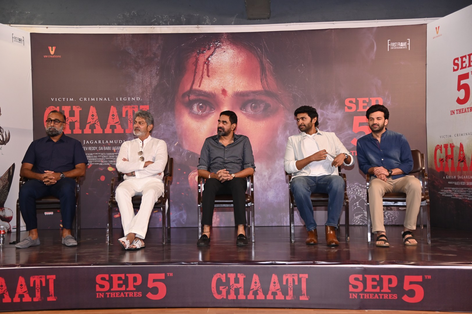 Cast and crew seated on stage at event