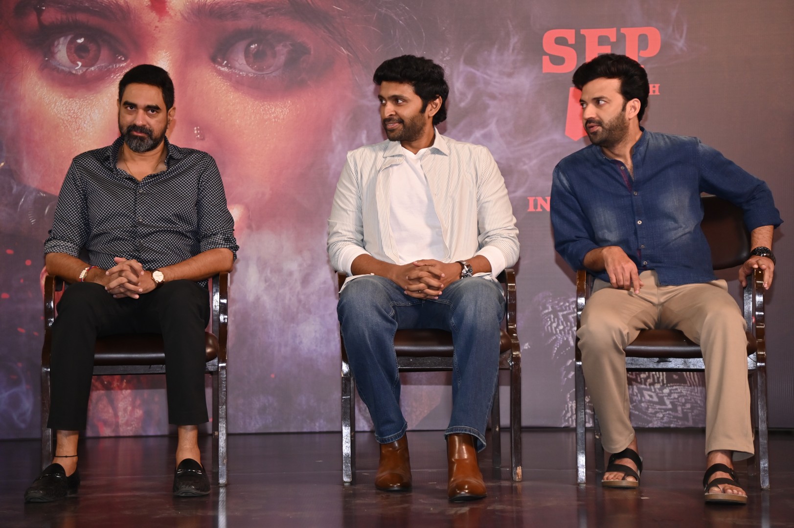 Krish, Vikram, and Chaitanya seated during event