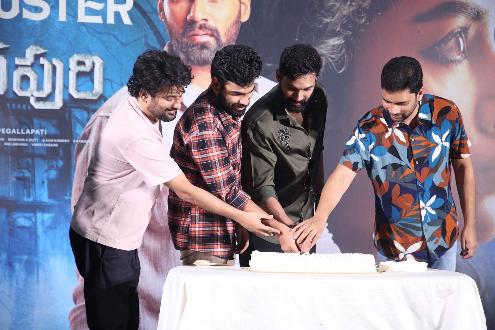 Film team cutting celebration cake together