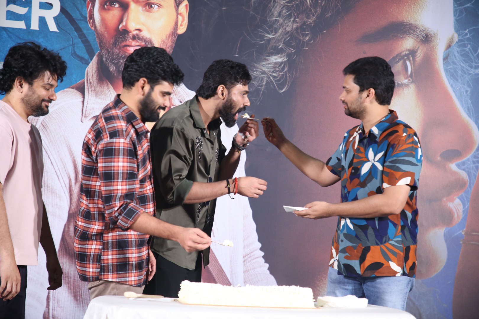 Producer feeding cake to lead actor