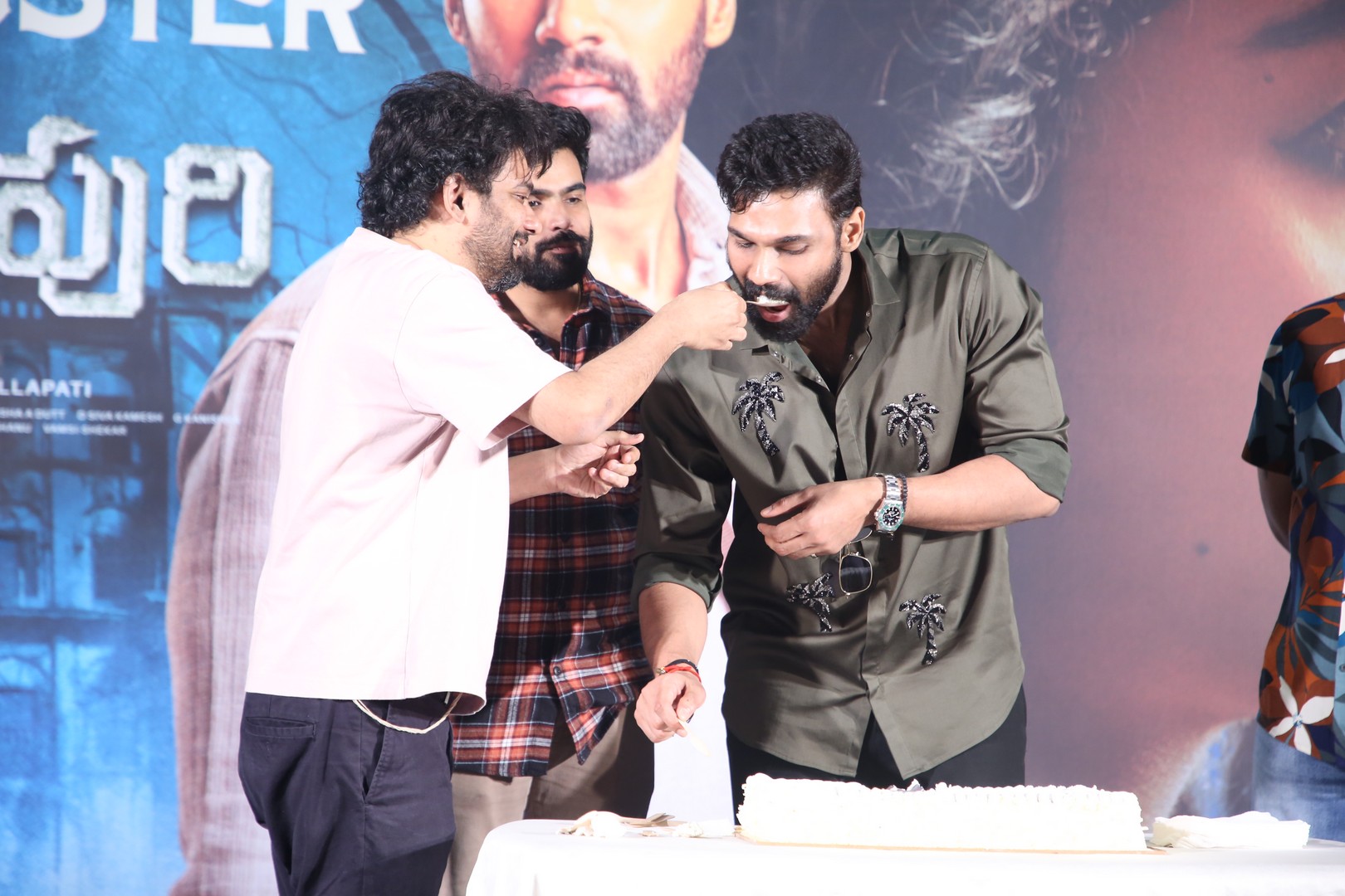 Music director feeding cake to actor