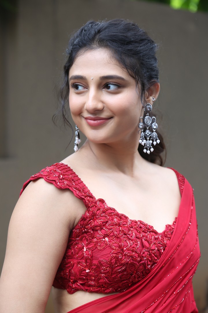 Ritika Nayak in red saree with statement earrings