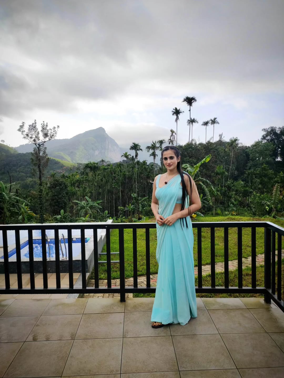 Thapaswini Poonacha radiant grace in blue saree mountain backdrop