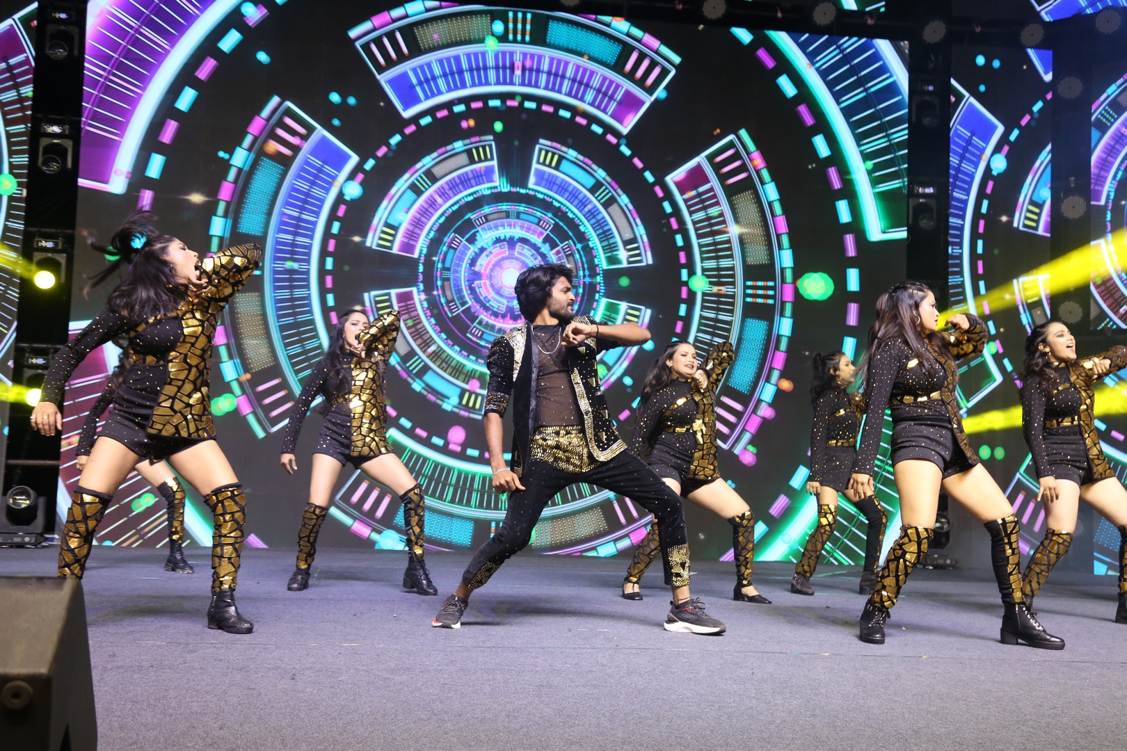 Dancers performing energetically on stage during Mass Jathara event
