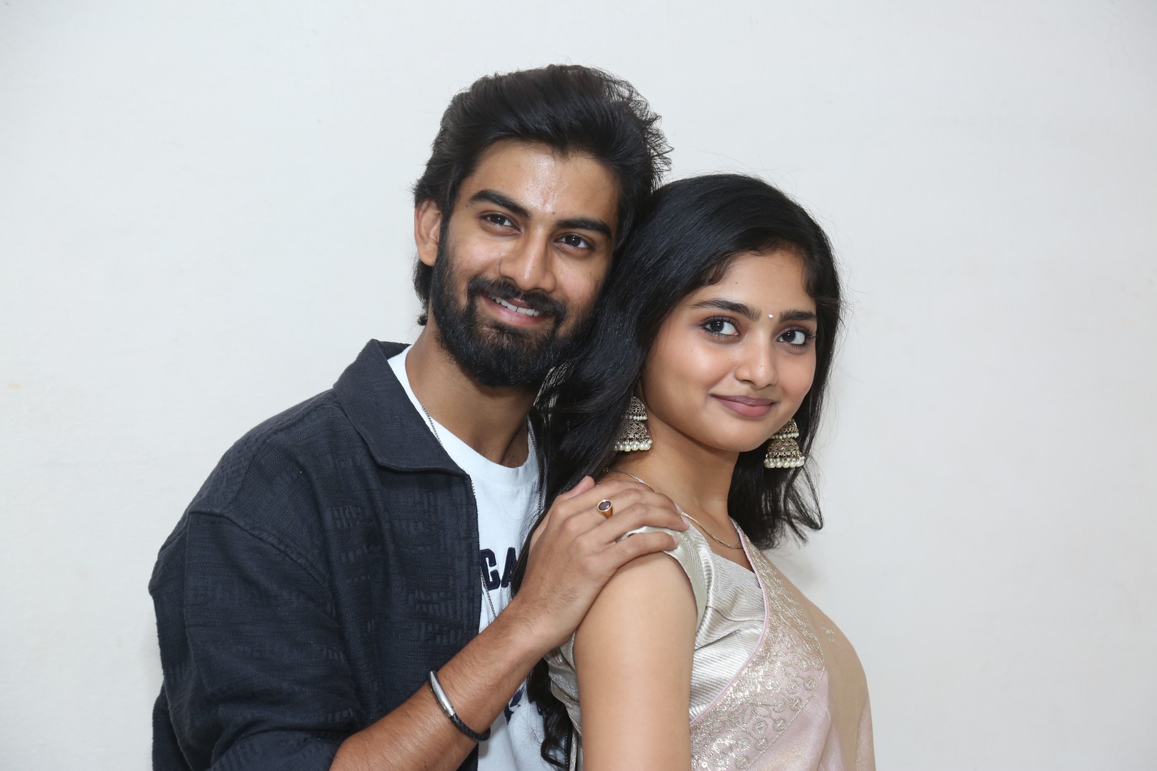 Sathvik Varma and Preeti Neha smiling for cameras at press meet
