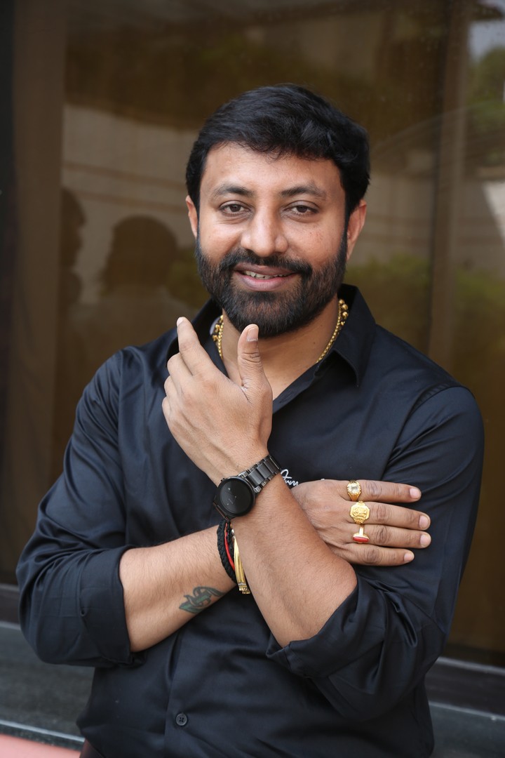 Satish poses confidently in sleek black outfit