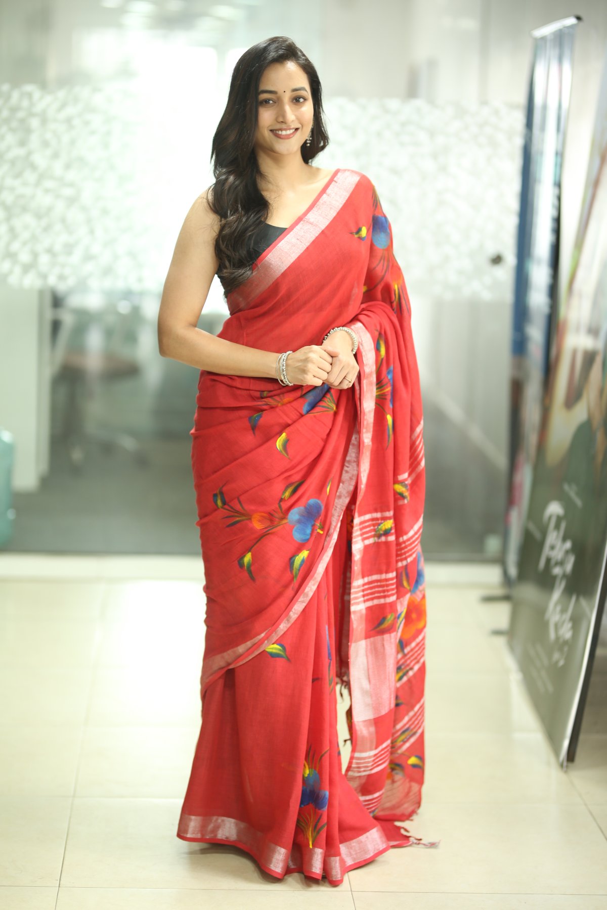 Srinidhi Shetty in red saree with floral accents and confidence