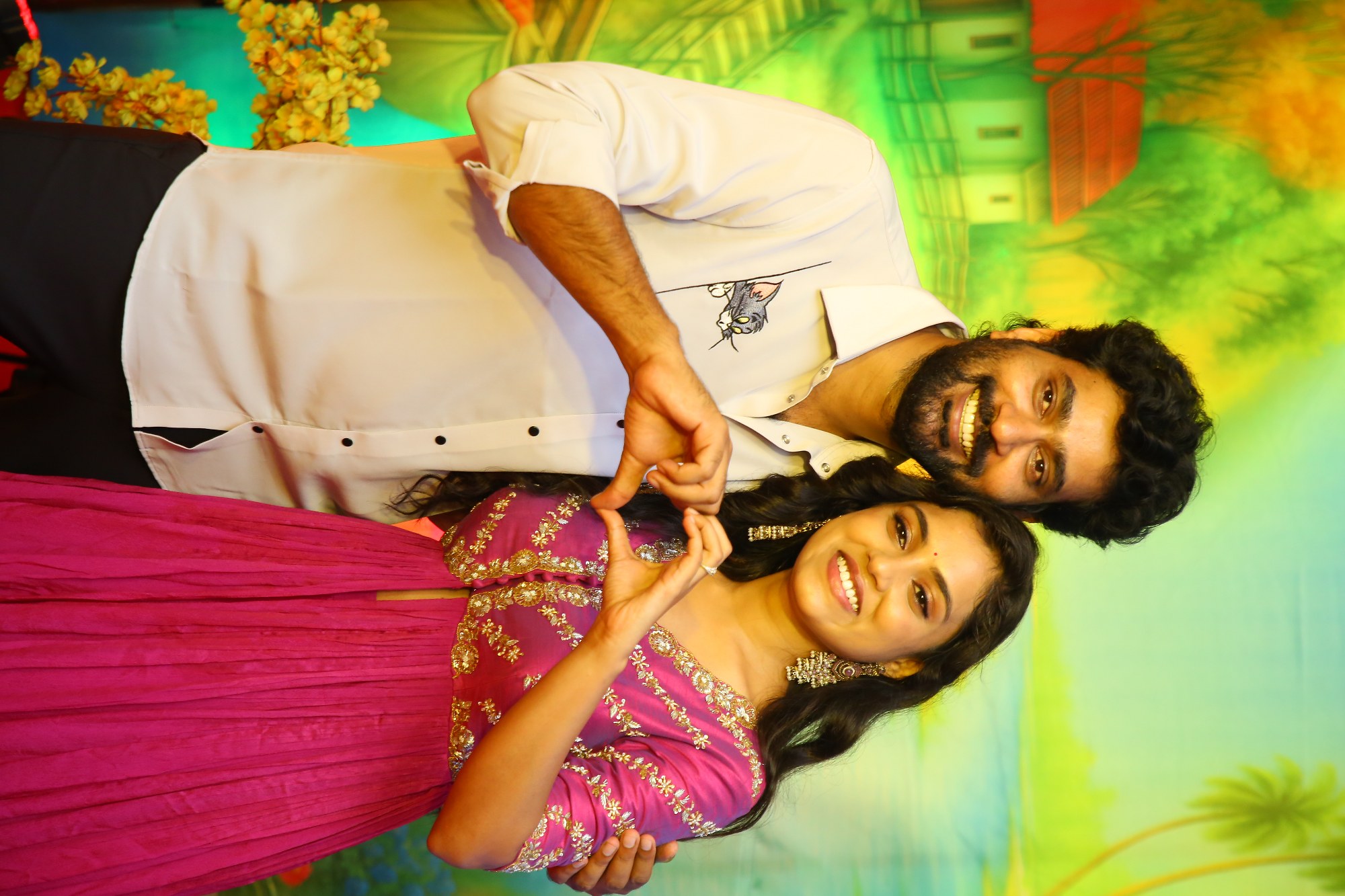 Thiruveer and Teena Sravya making heart symbol for media