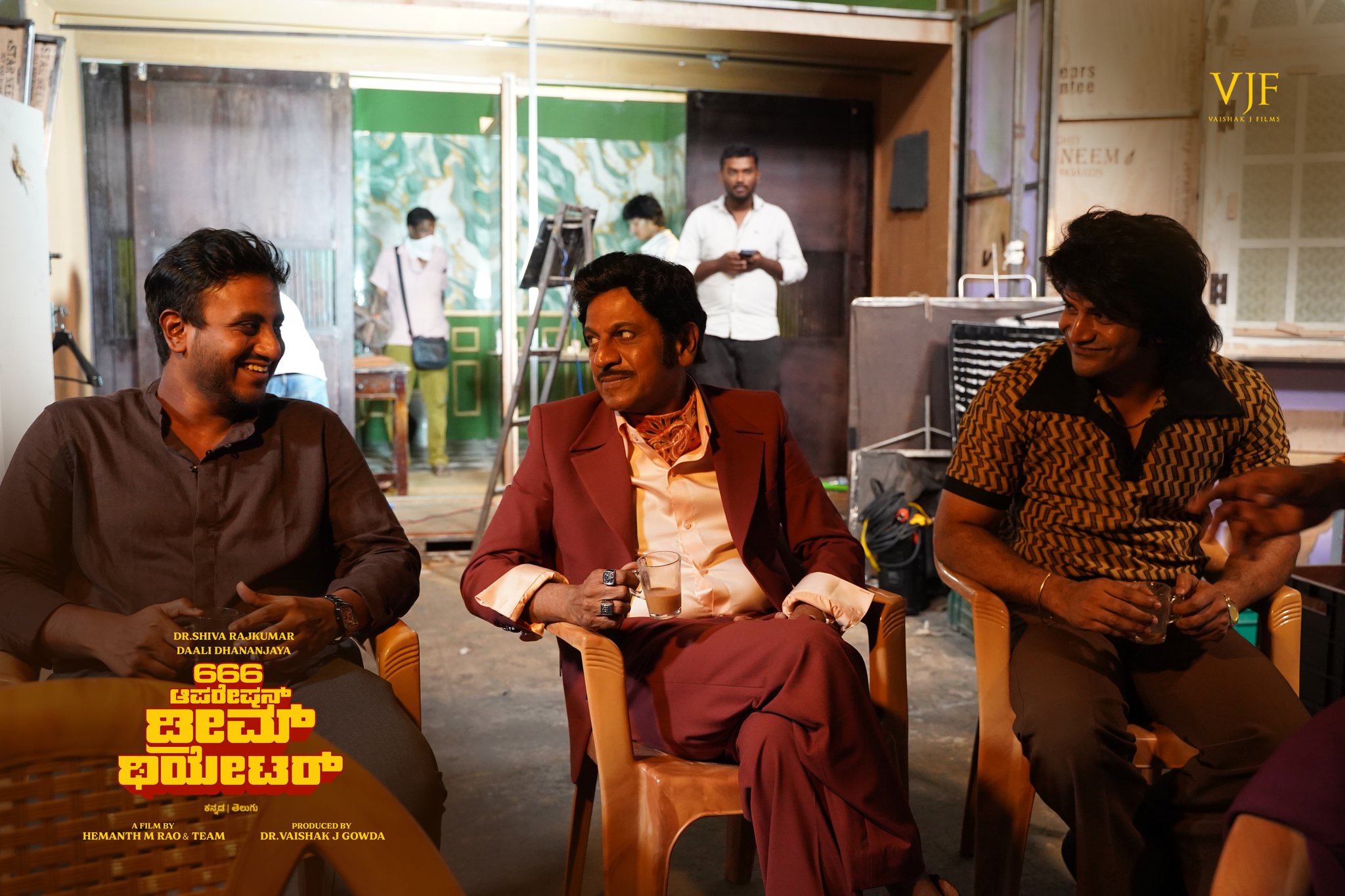 Crew members sitting together, smiling and enjoying coffee on set.