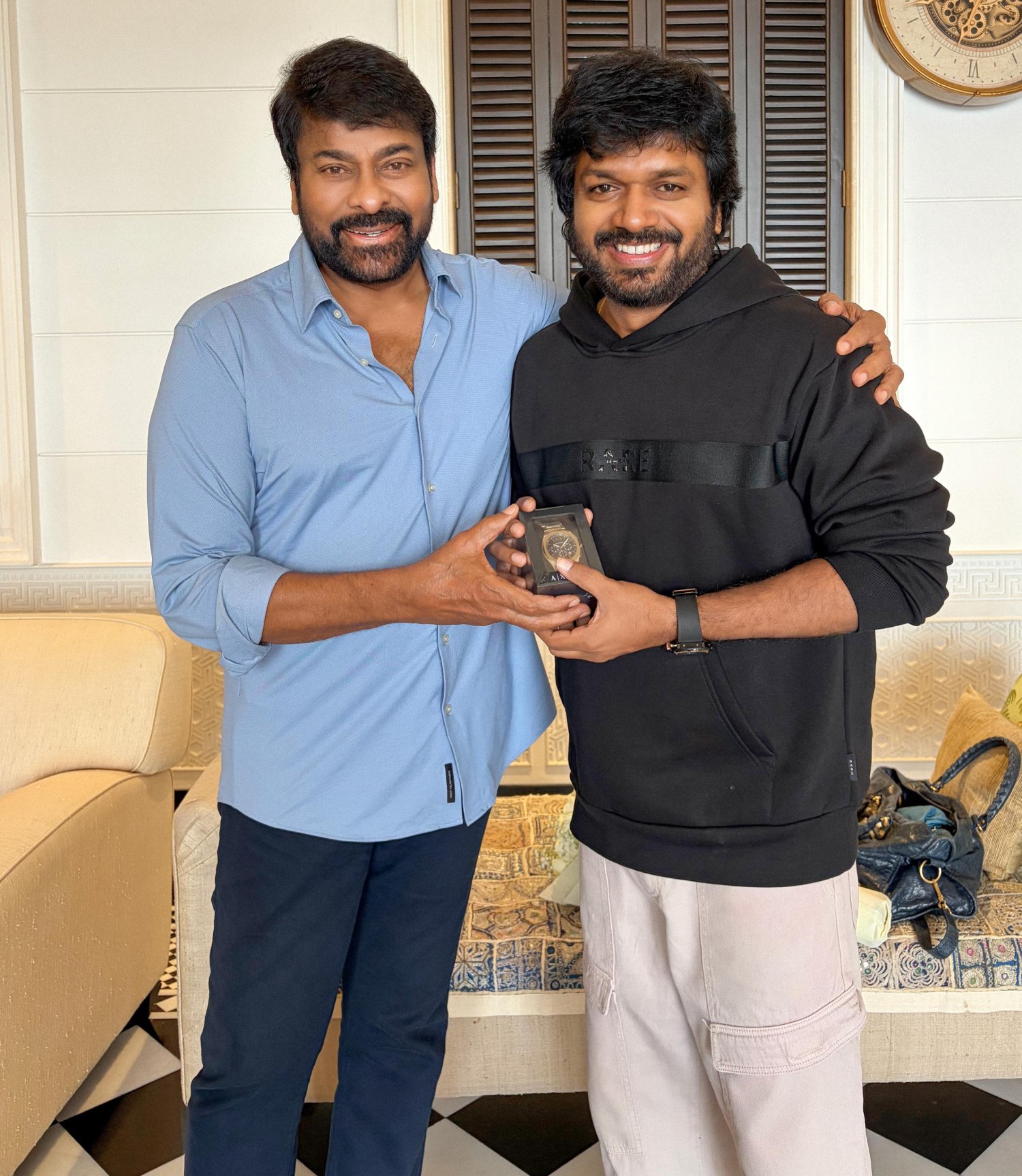 Two individuals exchanging a heartfelt birthday gift gesture