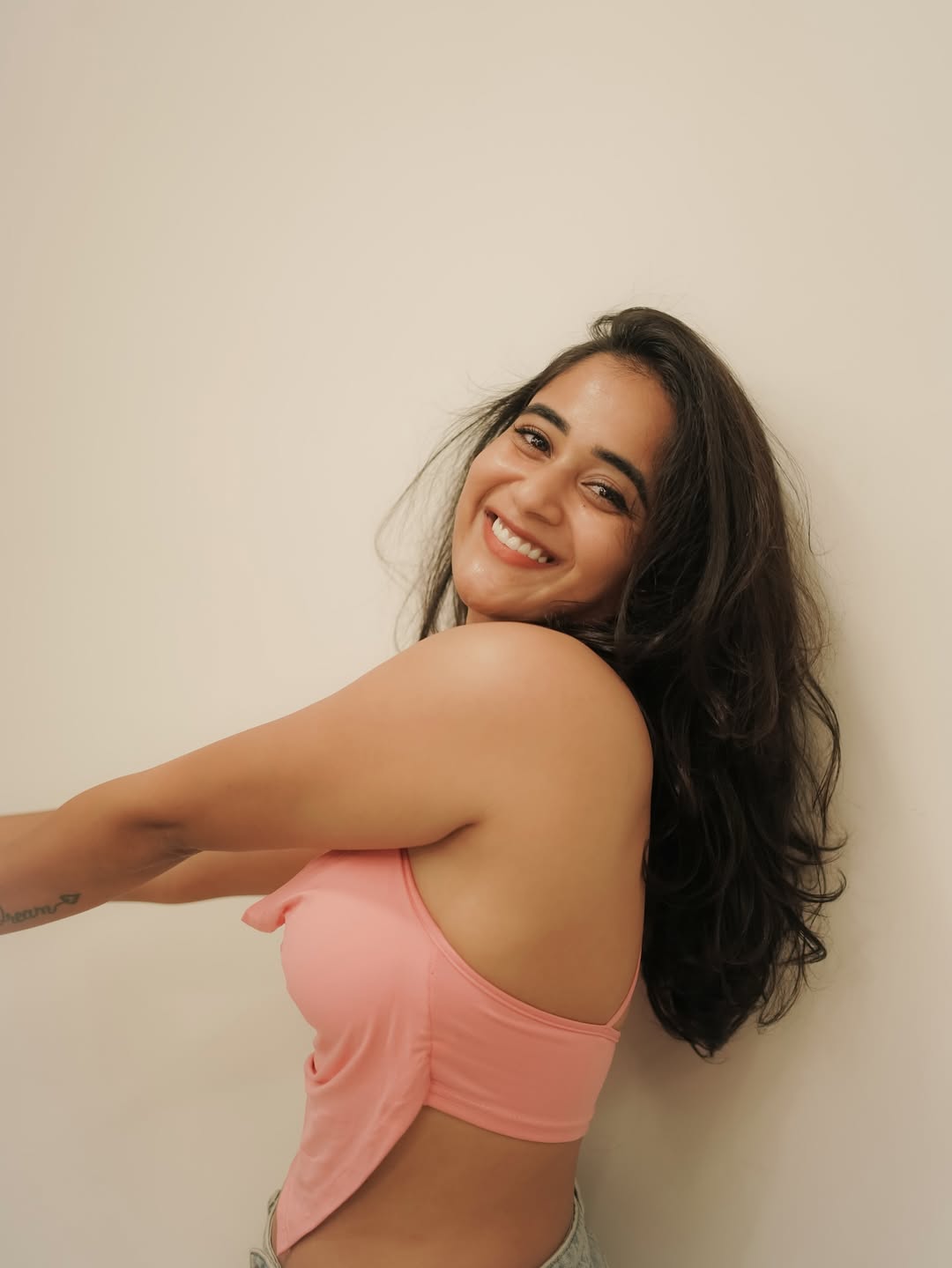 Deepthi Sunaina smiles radiantly in pastel pink style