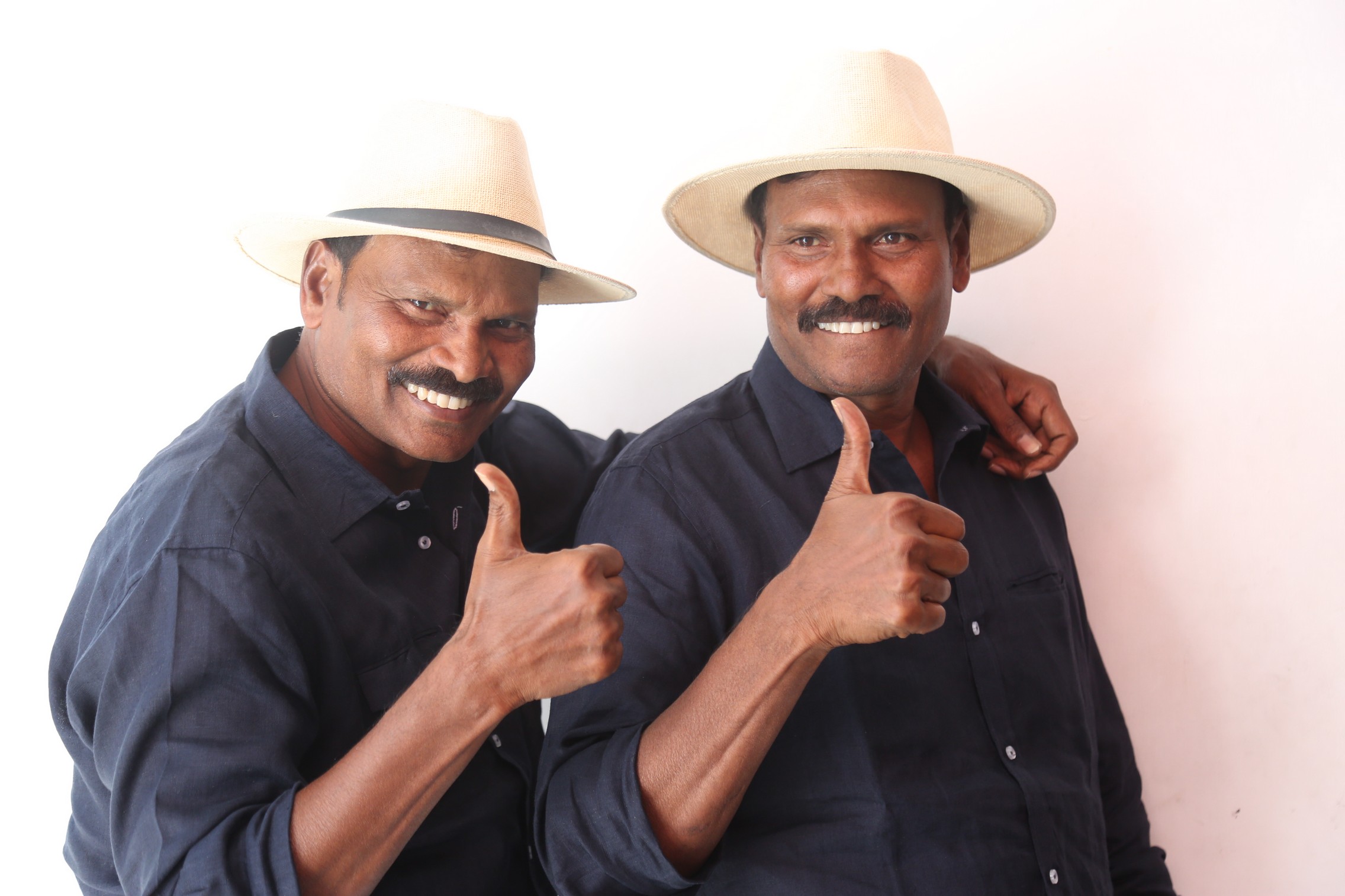 Ram Laxman posing with matching hats and thumbs up