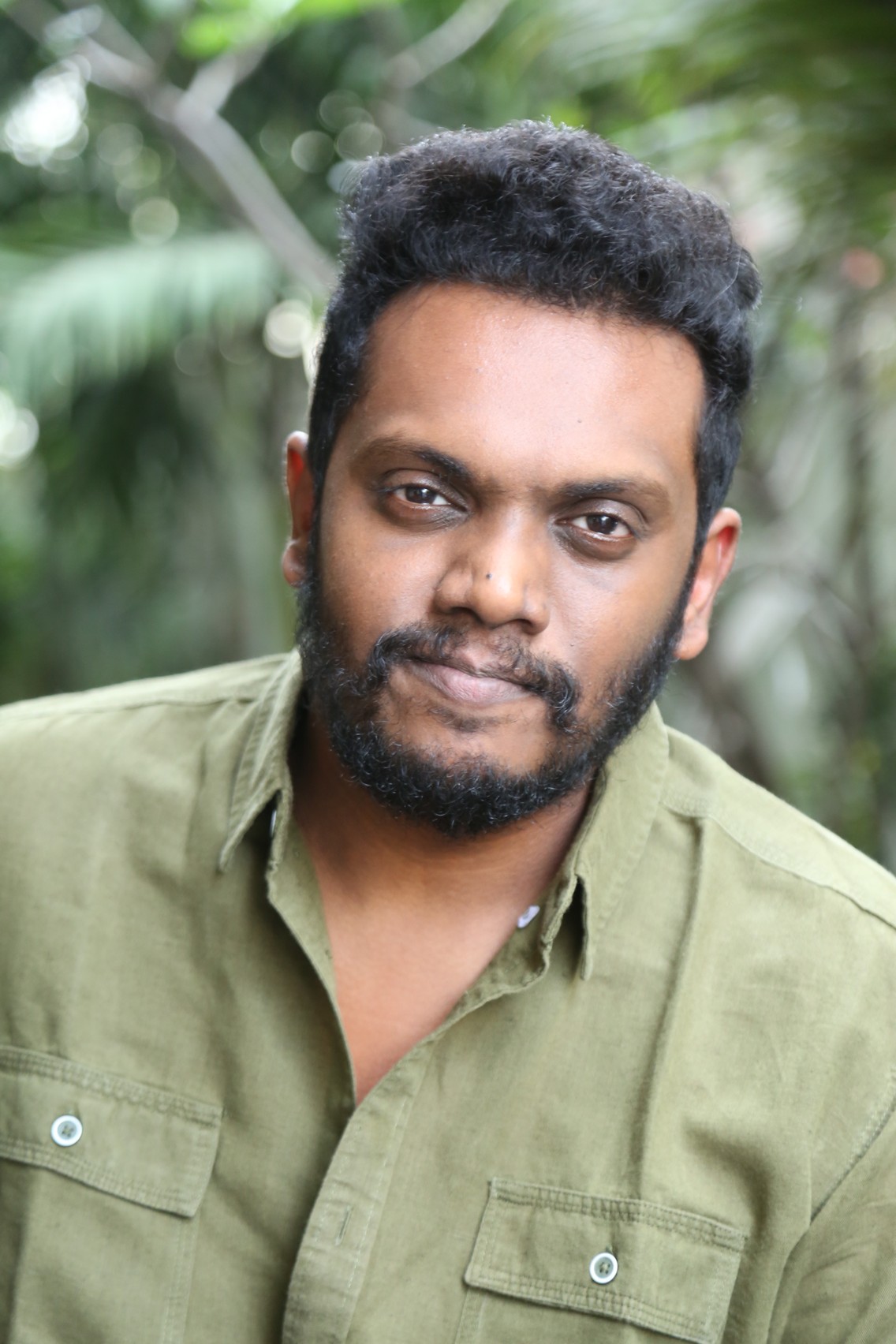 Sandeep Raj posing in rugged casual green outfit