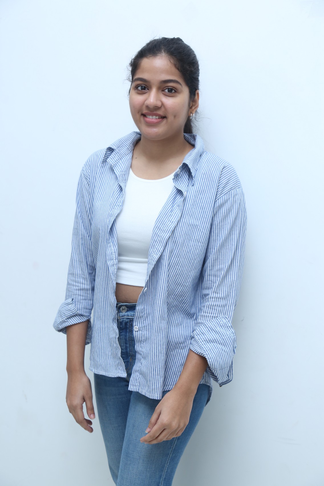 Tejaswi Rao posing in polished striped outfit