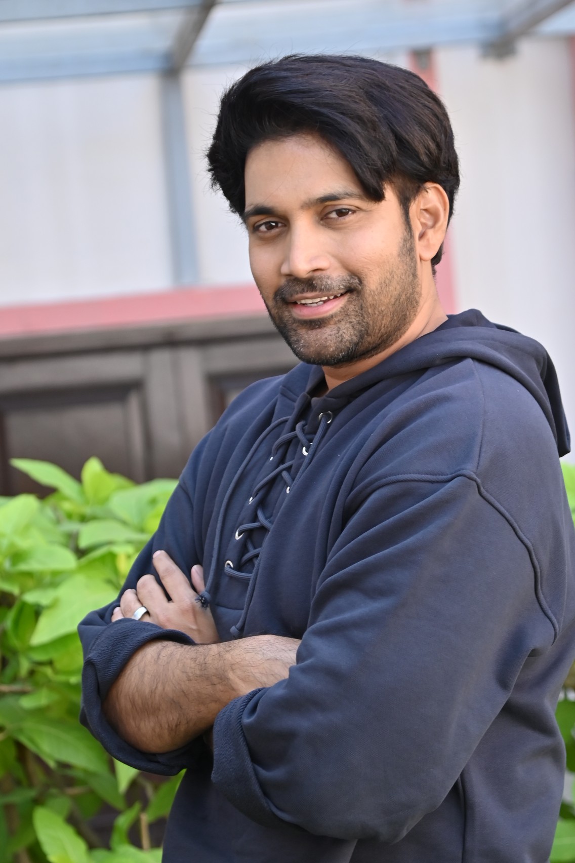Vikranth Reddy posing stylishly in a hoodie with charm