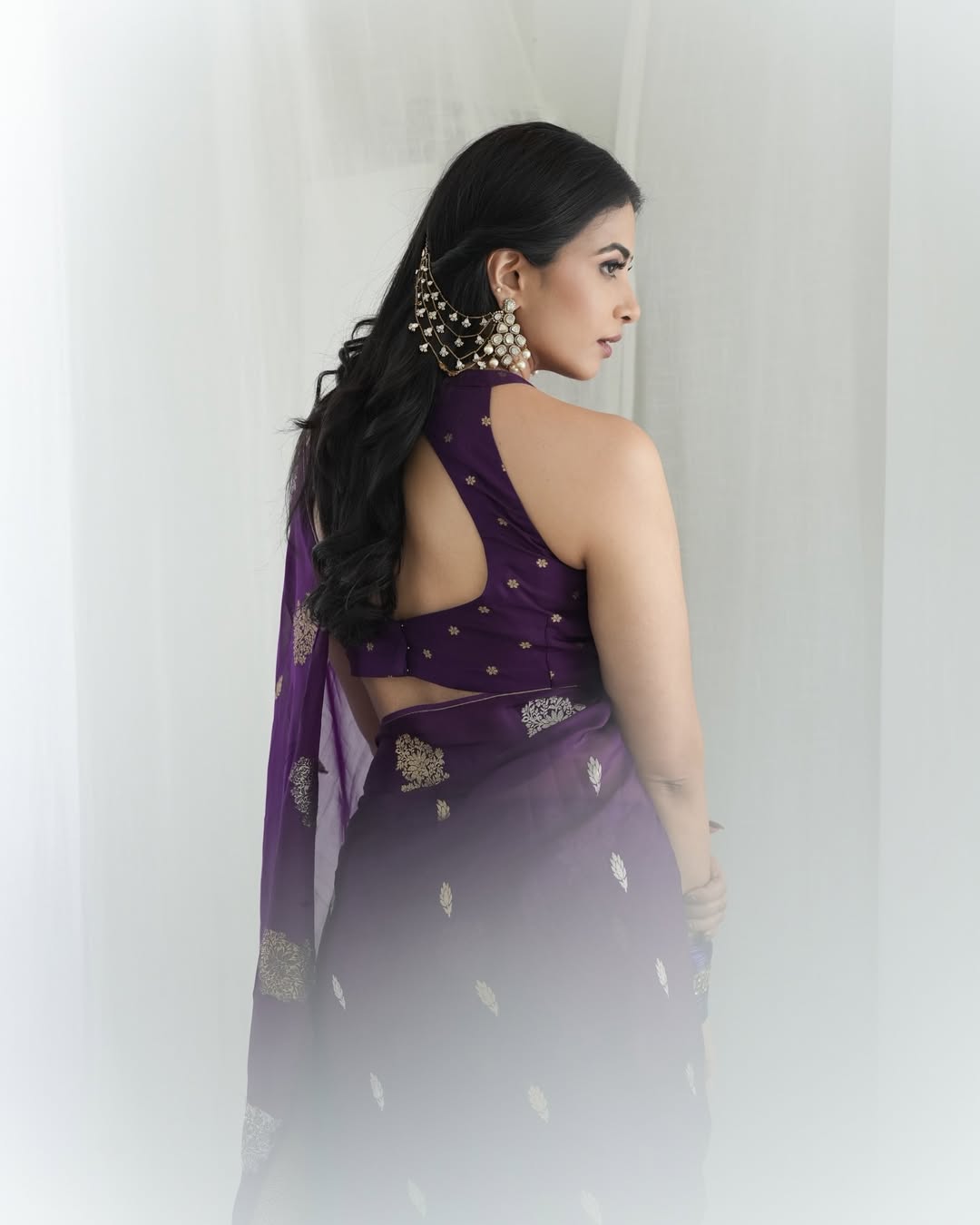 Kavya Shetty wearing purple saree with gold jewellery