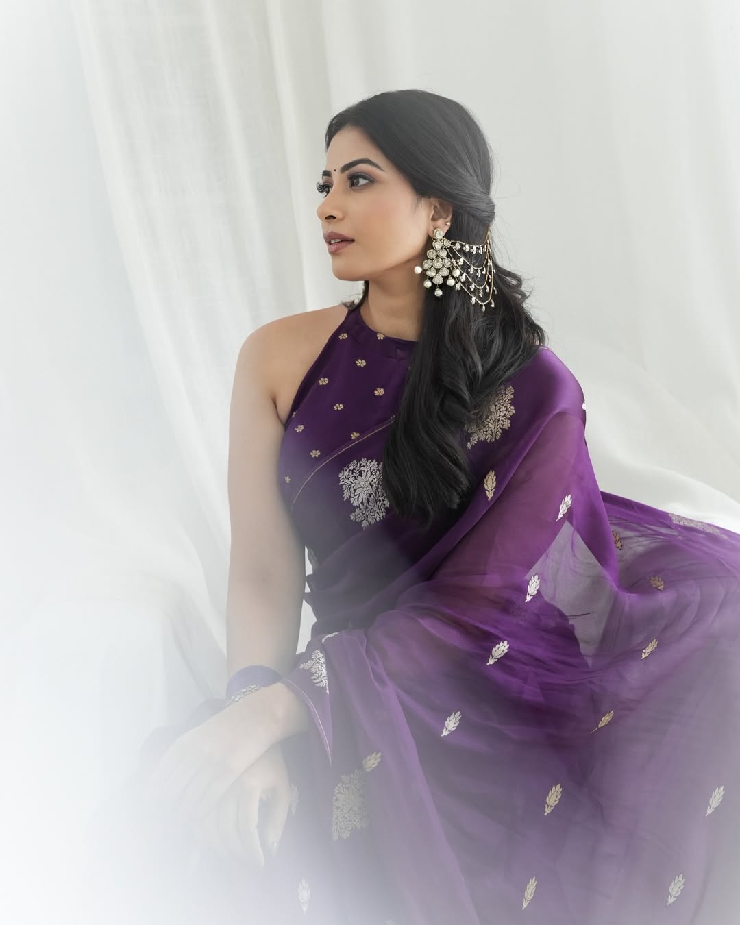 Kavya Shetty posing gracefully in traditional purple saree