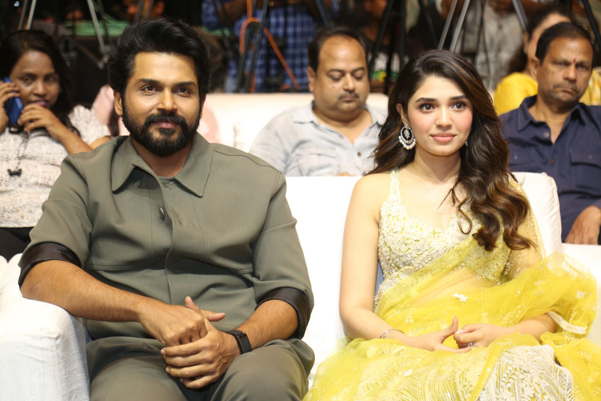 Karthi and Krithi Shetty seated together at event