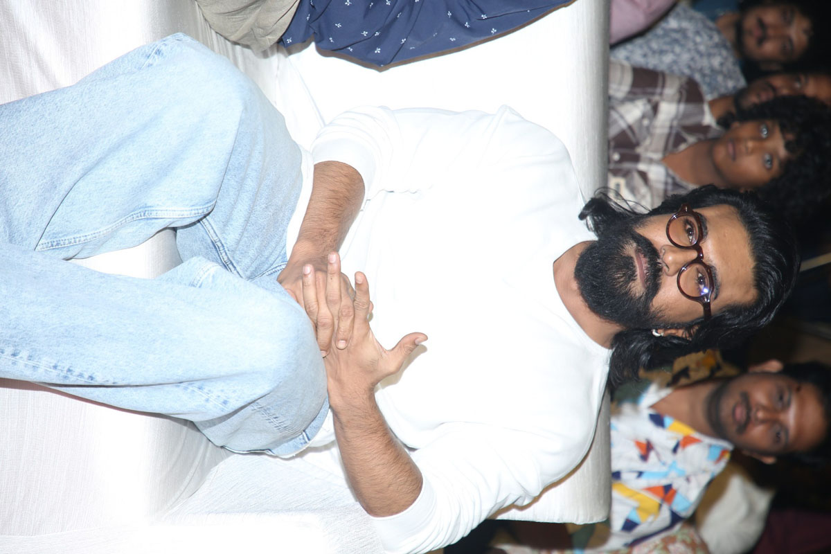 Ram Charan seated at event
