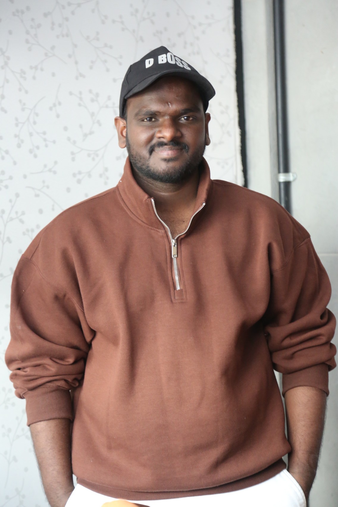 Nanduri Emmanuel smart casual hoodie look with cap