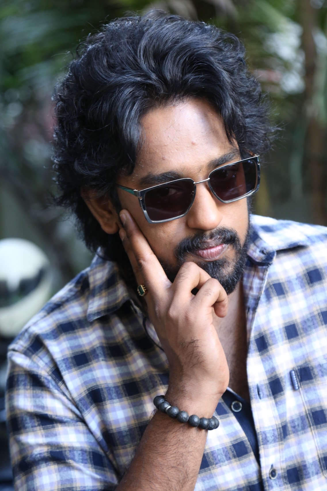 Roshan Kanakala posing confidently with stylish sunglasses