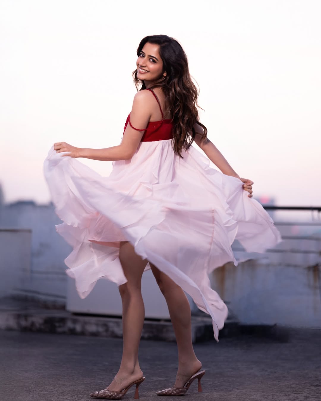 Ashika Ranganath twirls gracefully in playful elegant red dress