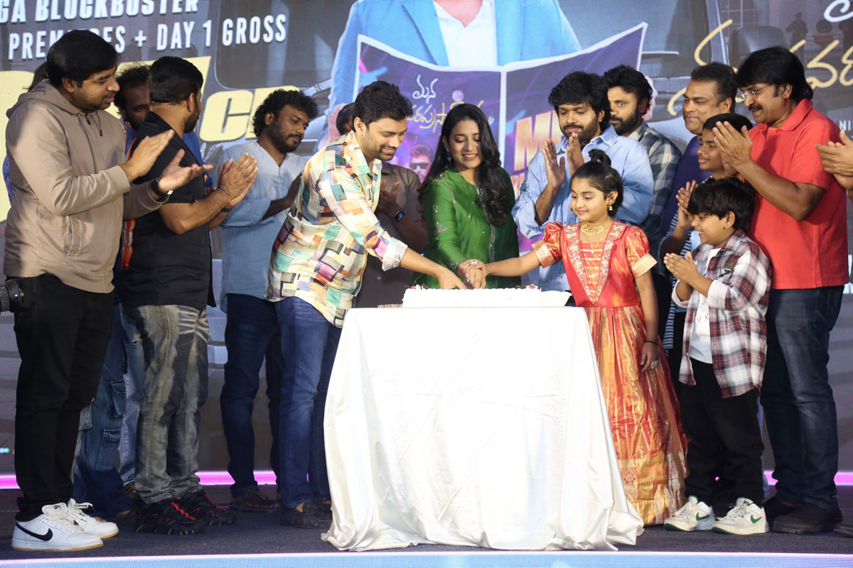 Team cutting celebration cake on stage