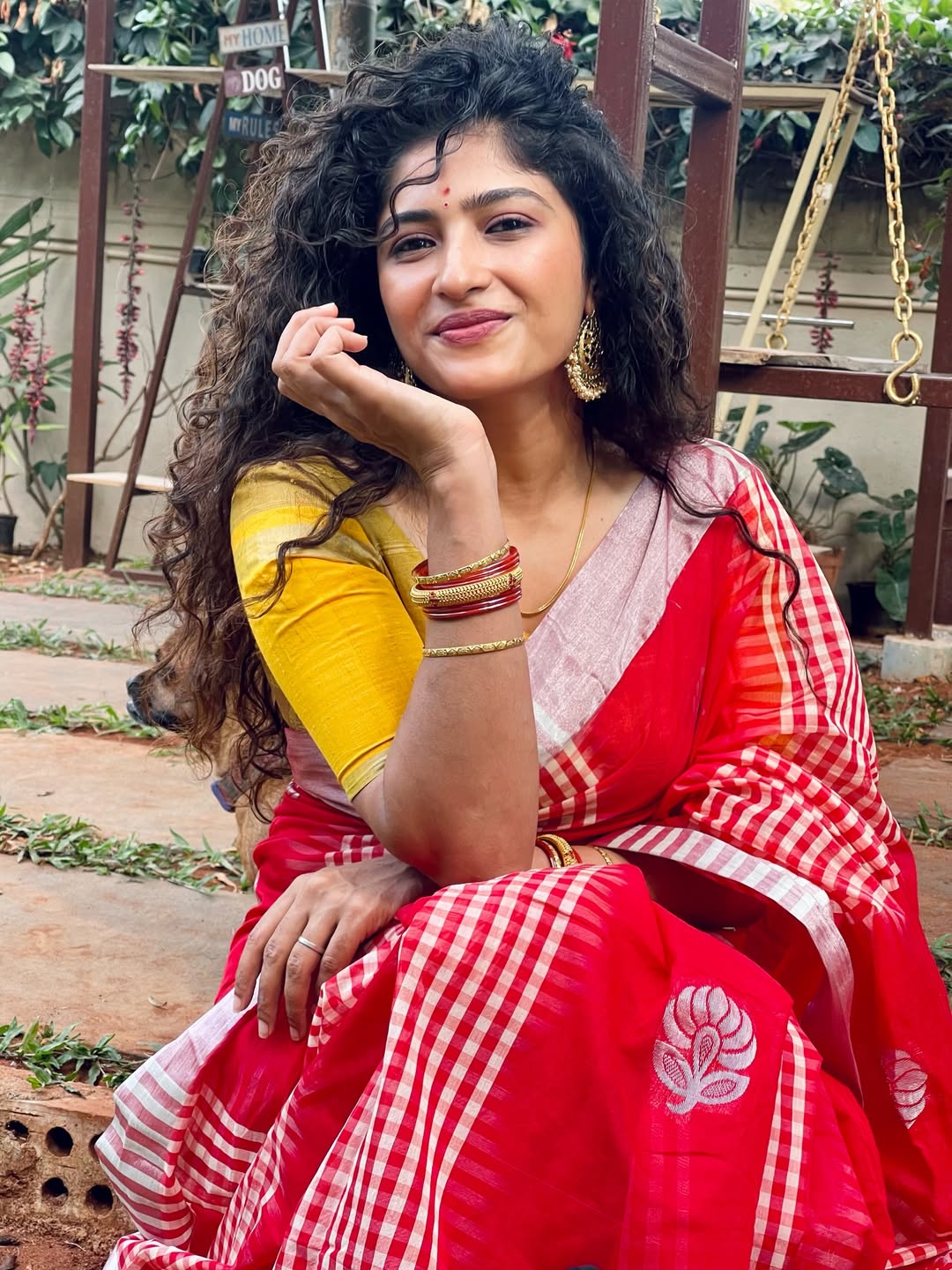 Roshni Prakash wearing vibrant red yellow saree smiling