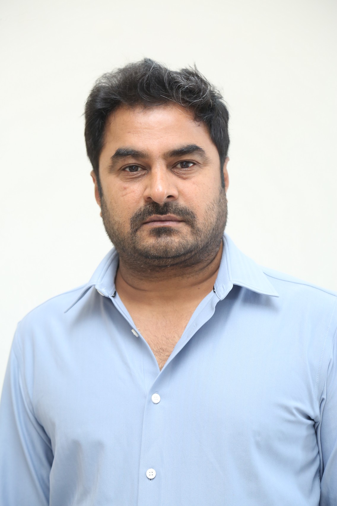 Sudhakar Cherukuri posing confidently in formal wear