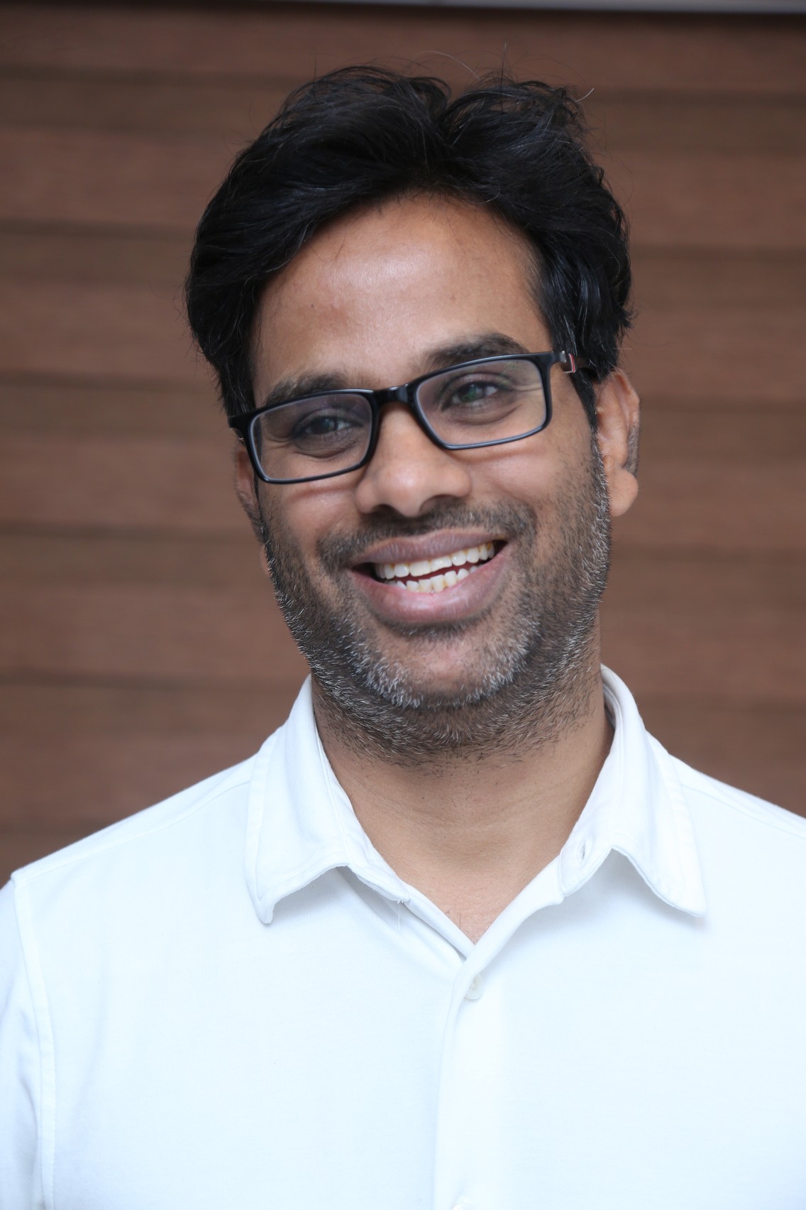 Anudeep KV smiling in smart formal wear