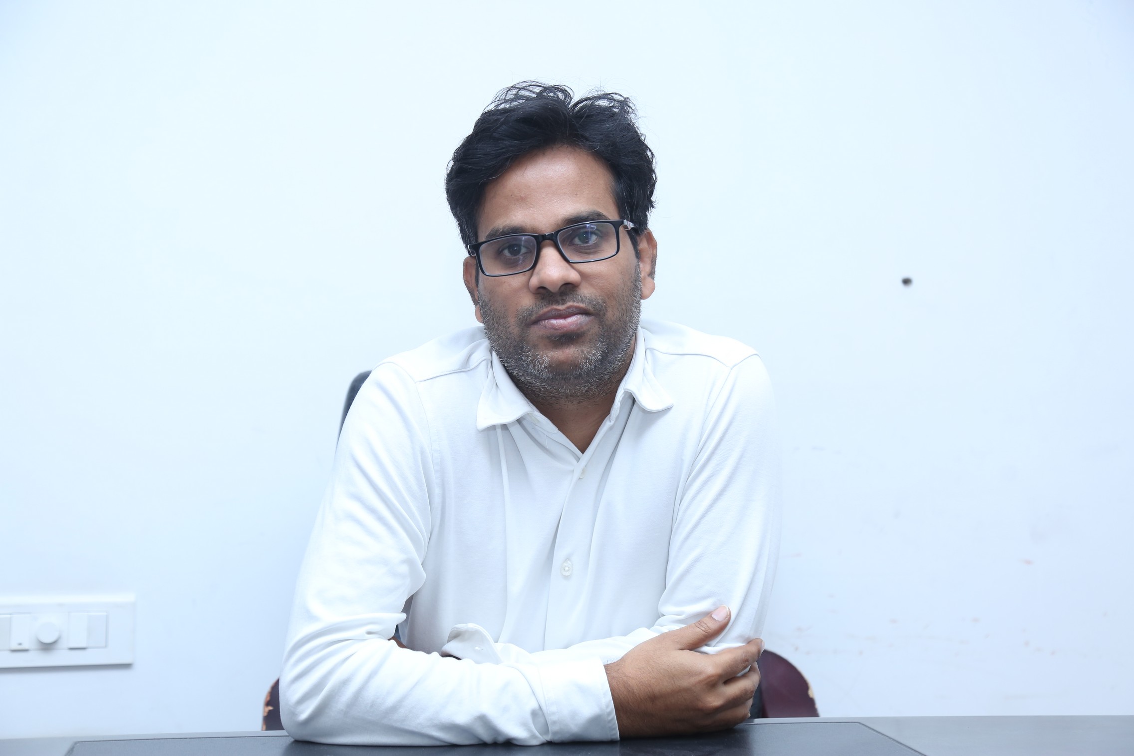 Anudeep KV thoughtful pose in white shirt